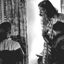 Jamie Lee Curtis con i piccoli Brian Andrew e Kyle Richards controlla che fuori non ci sia nessuna 'ombra della strega' in una scena di Halloween