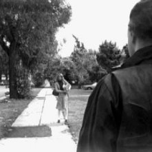 Nick Castle (di spalle) pedina Jamie Lee Curtis in una foto promozionale per Halloween