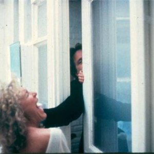 Michael Douglas (seminascosto, dietro la porta) e Glenn Close in una scena di Attrazione fatale