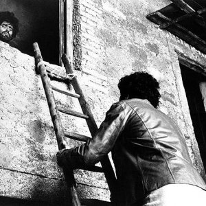 Tony Musante si reca a far visita a Mario Adorf, pittore dalle strane abitudini alimentari in una scena de L'uccello dalle piume di cristallo