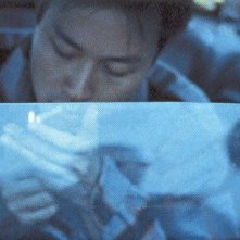 Leslie Cheung si accende una sigaretta in una foto di scena di Happy Together