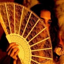 Una misteriosa Paz Vega si nasconde dietro un ventaglio in una scena di Per amare Carmen