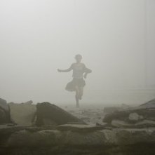 Radha Mitchell corre nell'inquietante nebbia di cenere in una scena di SILENT HILL