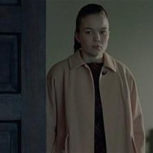 14.	Attacco in asse, vediamo lo spigolo del corrimano in basso a destra, una porta aperta alla quale la ragazza si affaccia, la mdp è posta allinterno della stanza