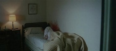 15. Controcampo verso linterno della stanza. Un corpo sul letto, sangue sul muro