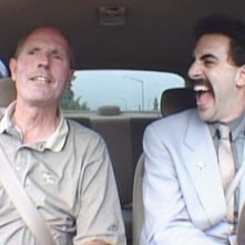 Sacha Baron Cohen accanto a un venditore di auto in una scena di 'Borat'