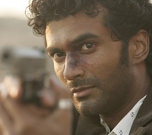 Heroes Volume II - Episodio 9: un primo piano di Mohinder (Sendhil Ramamurthy) che mira con la pistola