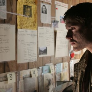 Jensen Ackels osserva gli indizi raccolti da suo padre appesi alla camera di motel nell'episodio 'la caccia ha inizio'