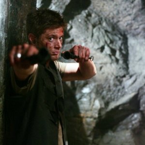 Jensen Ackles punta le sue armi contro il mostro che sta per divorare suo fratello e la famiglia Collins nell'episodio Wendigo di Supernatural