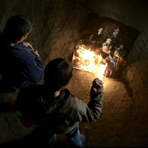 Jared Padalecki e Jensen Ackles, i fratelli Winchester, mentre bruciano la tela infestata nell'episodio 'Il quadro maledetto' di Supernatural