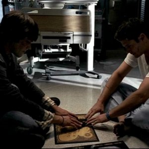 Jensen Ackles e Jared Padalecki, nei panni dei fratelli Winchester mentre tentano di comunicare con una tavoletta oujia nell'episodio, 'In my time of dying'