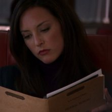 Lola Glaudini interpreta Elle, mentre esamina il file del prossimo caso nell'episodio 'Derailed' della serie Criminal Minds