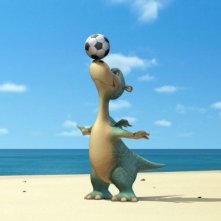 Il dinosauro Impy gioca con un pallone in una scena del film d'animazione Impy e il mistero dell'isola magica