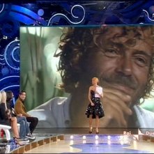 Isola dei Famosi 6: Simona Ventura è la conduttrice del reality di RaiDue. Sullo schermo, alle sue spalle, l'attore Massimo Ciavarro