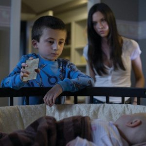 Odette Yustman (alle spalle del bambino) in una scena del film Il mai nato