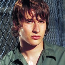 Roswell: Un primo piano di Brendan Fehr appoggiato a una rete