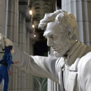 Ben Stiller viene aiutato da un'enorme statua di Abramo Lincoln in una scena del film Una notte al museo 2: la fuga