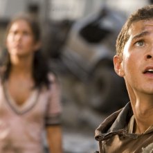 Shia LaBeouf in primo piano con Megan Fox alle spalle in una scena del film Transformers