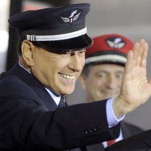 Berlusconi sorridente, indossa un copricapo delle Ferrovie dello Stato.