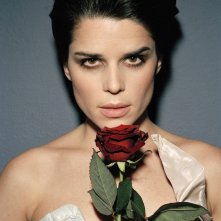 un primo piano di Neve Campbell, con rosa rossa