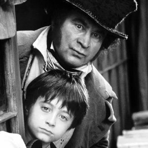 Un immagine promozionale in bianco e nero del film David Copperfield, con Daniel Radcliffe e Bob Hoskins