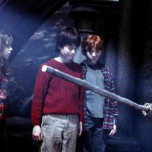 Emma Watson, Daniel Radcliffe e Rupert Grint osservano un manico scopa nel film Harry Potter and the Sorcerer's Stone