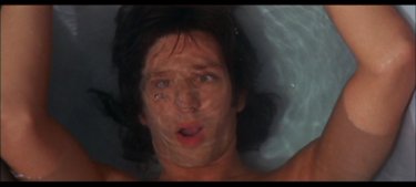 Michael Brandon a mollo nella vasca in una scena del film Quattro mosche di velluto grigio (1971)