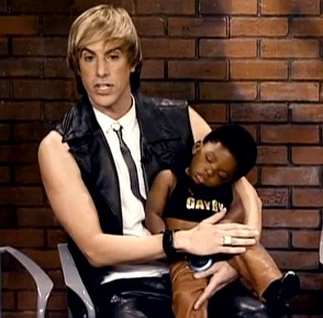 Sacha Baron Cohen nei panni di Bruno in una scena del film in cui presenta il suo bambino adottivo di colore al pubblico di un talk show