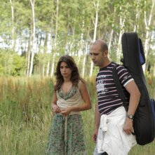 Chitarra in spalla per Luca Medici in una scena di Cado dalle nubi, il primo film di Checco Zalone