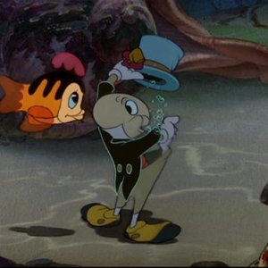 Il Grillo parlante alle prese con un pesciolino in una divertente scena del film d'animazione Pinocchio (1940)