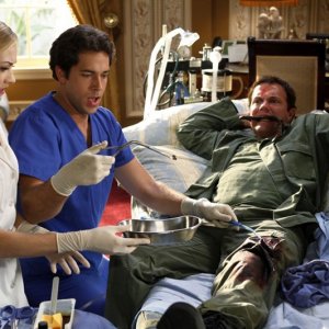Zachary Levi e Yvonne Strahovski estraggono il proiettile dalla gamba di Adam Baldwin nell'episodio Chuck Vs. The Angel de la Muerte