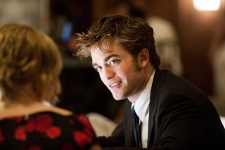 Robert Pattinson parla con Emilie de Ravin (di spalle) in una scena del film Remember Me