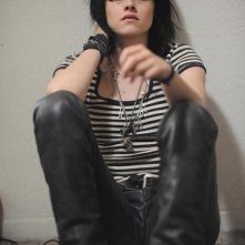 Kristen Stewart seduta a terra in una scena del film The Runaways