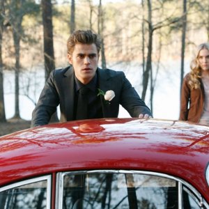 Stefan (Paul Wesley) accanto alla sua auto, con alle spalle Amber (Spencer Locke) in: Miss Mystic Falls di Vampire Diaries