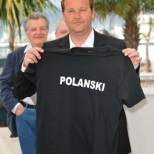 Cannes 2010, photocall di Des hommes et des dieux: Xavier Beauvois posa con una t-shirt di sostegno a favore di Roman Polanski