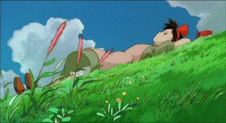 La piccola Kiki distesa su un prato in una scena del film d\'animazione Kiki consegne a domicilio