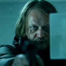 Primo piano inquietante di Jürgen Rißmann dal film Snowman's Land