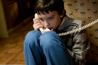 Kodi Smit-McPhee al telefono in una scena del film Let Me In