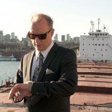 Xander Berkeley guarda l'orologio nell'episodio The Guardian di Nikita