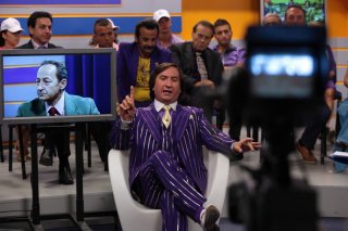 Antonio Albanese e Salvatore Cantalupo (nello schermo) nella commedia Qualunquemente