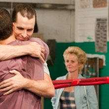 Mark Wahlberg e Christian Bale in un abbraccio fraterno con Melissa Leo sul fondo in The Fighter