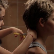 Zoe Heran si lascia tagliare i capelli da Malonn Lévana in una scena di Tomboy