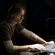 Robert Carlyle lavora al computer nell'episodio Alliances di Stargate Universe