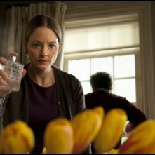 Jodie Foster alle prese con i fiori in salotto in una scena di Carnage