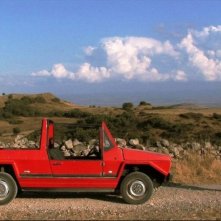 Domenico Montixi osserva la sua automobile in una scena del film Sagràscia