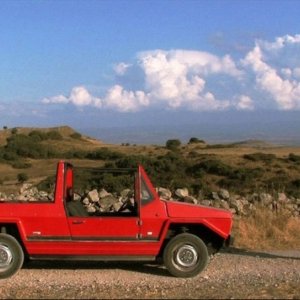 Domenico Montixi osserva la sua automobile in una scena del film Sagràscia