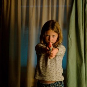 Little Glory: Isabella Blake-Thomas in una scena del film impugna una pistola giocattolo