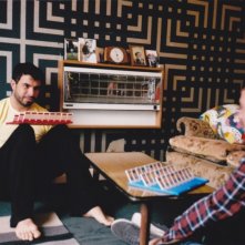 Tom Cullen e Chris New in una scena del dramma sentimentale Weekend alle prese con un gioco da tavolo