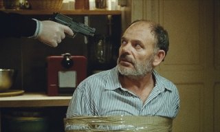 Le nevi del Kilimangiaro: Jean-Pierre Darroussin minacciato con una pistola in una scena tratta dal film