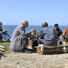 Miracolo a Le Havre: André Wilms al mare con un gruppo di stranieri in una scena del film